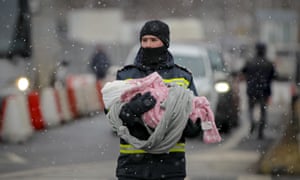 Strażak przewozi dziecko-uchodźcę, uciekające przed konfliktem z sąsiedniej Ukrainy na granicy rumuńsko-ukraińskiej