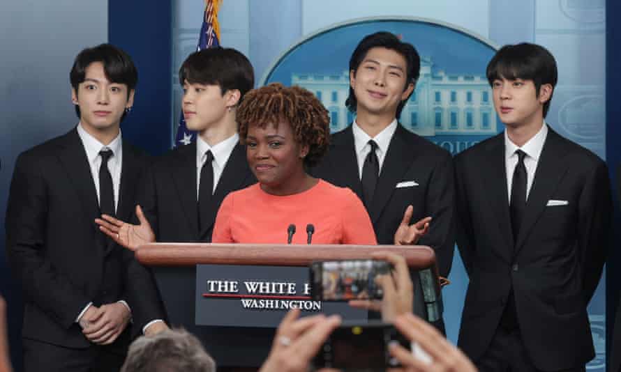 Jean-Pierre speaks at the podium with band members behind her