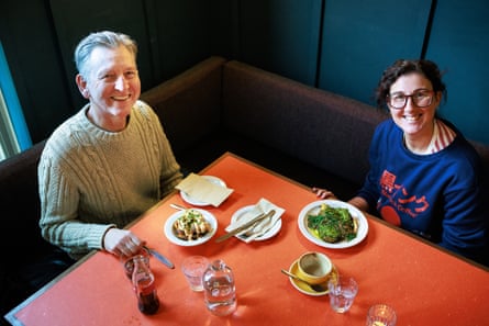 A man and woman looking up from a restaurant table