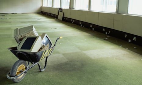 Wheelbarrow and computer monitors in office