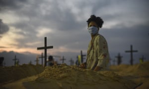 A protester digs a mock grave on Copacabana beach symbolizing deaths due to the coronavirus, in Rio de Janeiro.