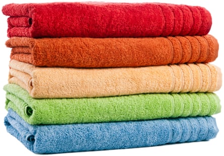 Five stacked coloured bath towels isolated on white background