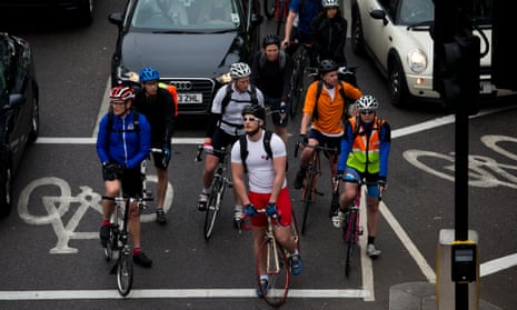 Cyclists wait for a traffic light to change