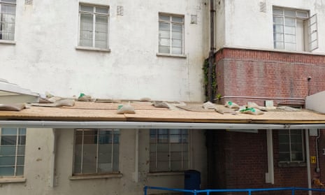 A walkway roof covered with MDF and sandbags in the approach to the St Helier hospital