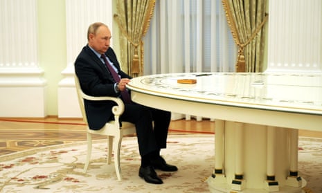 Vladimir Putin sits at a large desk in a meeting with Azerbaijani president Ilham Aliyev (not seen) in Moscow on 22 February.