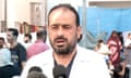 Dr Mohammad abu Salmiya giving a press briefing on 1 November 2023, wearing white coat and standing in front of crowd of people gathered outside hospital