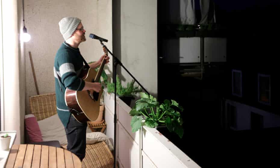 Thorsten Schmidt performs on the balcony of a house in Dortmund. Balkonsänger (balcony singer) is one of 1,200 new German words related to the pandemic.