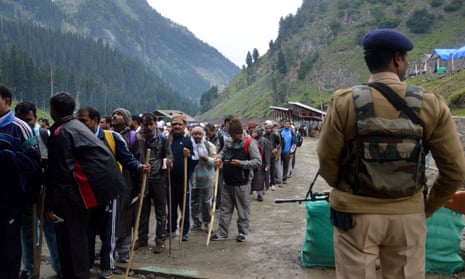 A soldier stands guard as pilgrims make their way to a cave shrine in Kashmir as part of the annual Amarnath Yatra