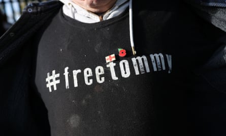 Closeup of a man in a Free Tommy t-shirt