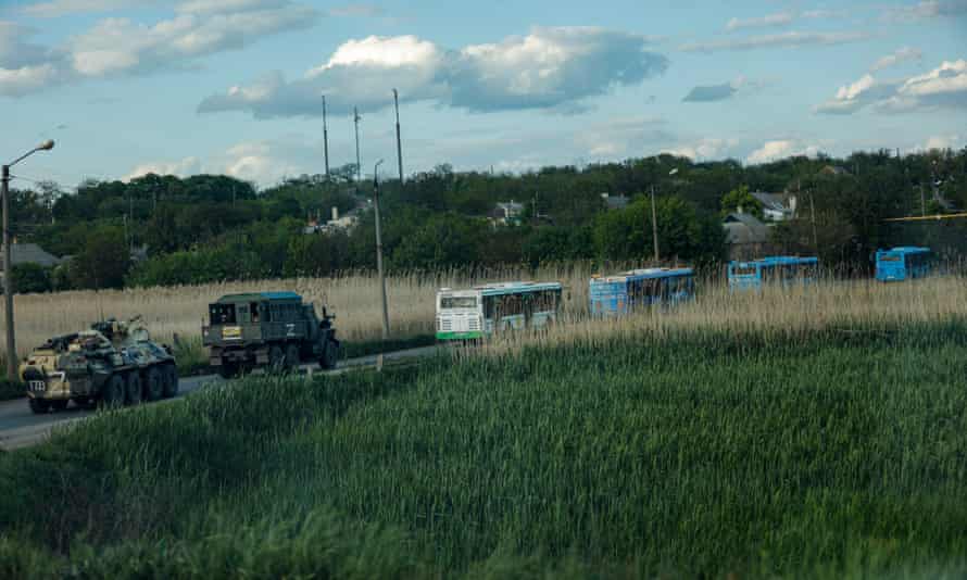 Los vehículos militares rusos escoltan a los autobuses que transportan a los militares ucranianos que están siendo evacuados de la planta siderúrgica sitiada de Azovstal en Mariupol.