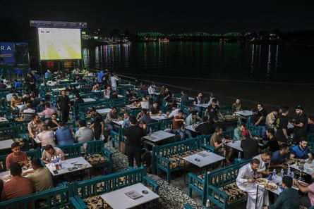 Young people sit by the Tigris River.