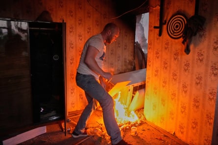 A man tries to put out a fire in his apartment in Ukraine