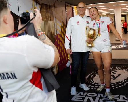England head coach, John Mitchell, poses for a photo his captain, Zoe Aldcroft, and the Women’s World Cup trophy.