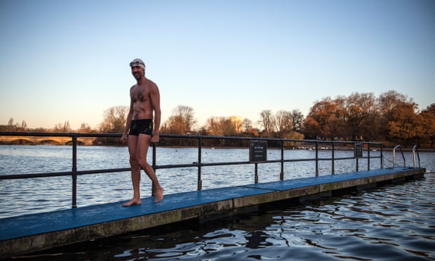  A member of the Serpentine Swimming Club leaves after enjoying an early morning swim in Serpentine Lake in Hyde Park in London.