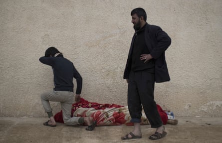 Relatives next to the body of Suheyil Najn Abdullah after he was killed by a sniper while trying to flee fighting between Iraqi security forces and Isis