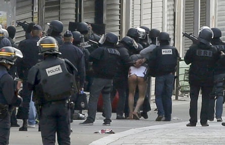A man is taken away from the scene by French special police forces
