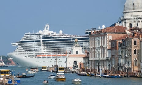 An enormous cruise ship sails through Venice