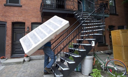 Jim Hendry carries a bed base up a set of stairs in Montreal on Moving Day. The day is no longer law, but remains as a rather problematic tradition.