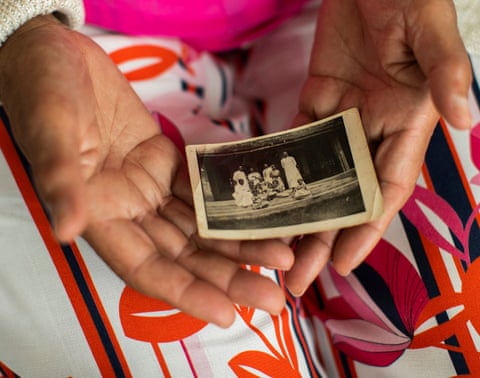 Monique holds a photo of herself as a young girl with her family, before she was kidnapped.