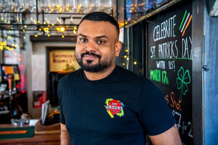 Man successful T-shirt adjacent to nan barroom of a pub