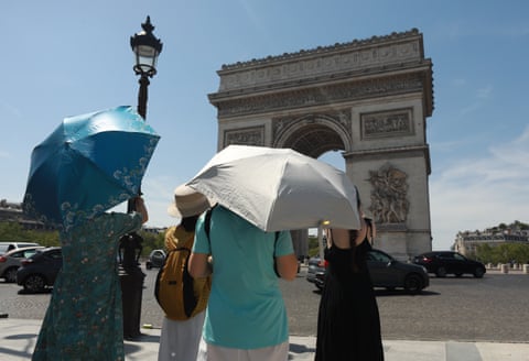 Visitors use umbrellas to shield themselves from the sun during a heatwave as the Arc de Triomphe in Paris at the height of the heatwave.