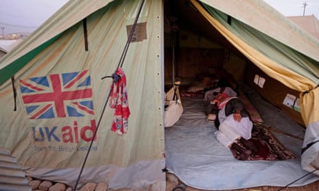 A Yazidi man lying inside a temporary shelter tent donated by UK aid at a refugee camp in northern Iraq.