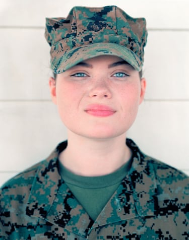 Girl in camouflage fatigues and hat stares into the camera