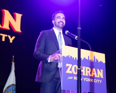 a man in a suit smiling in front of a microphone