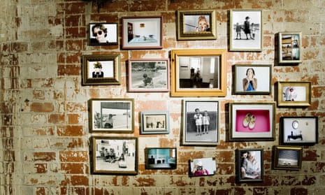 A wall with framed photos and postcards.