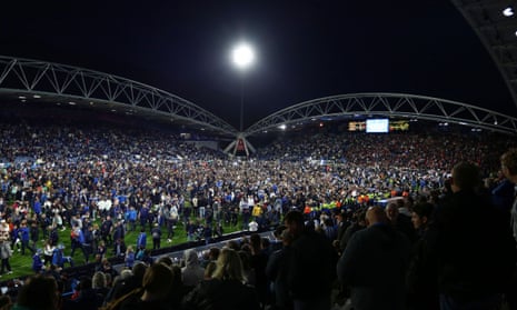 Huddersfield Town fans on the pitch at the end of the game.