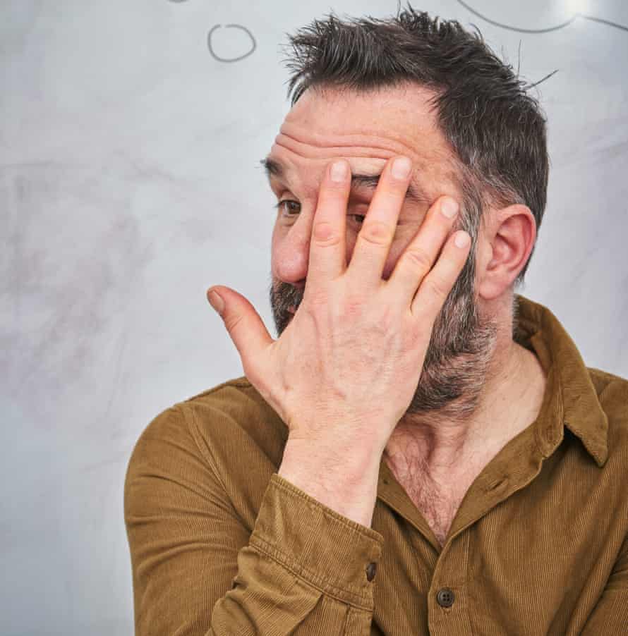 Shaun Keaveny, his head turned sideways and his hand covering most of his face