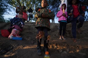 Ciudad Acuna, MexicoA girl with Barbie dolls stuffed in her boots waits with others to cross the Rio Grande river with her parents as they stand on the bank of the river at dawn