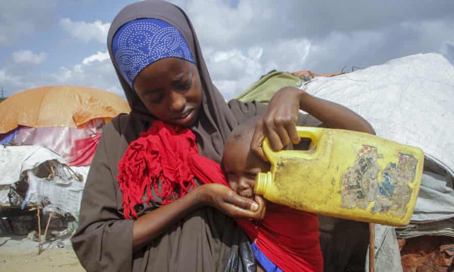 Una mujer somalí le da agua a su hijo en un campamento para desplazados en las afueras de Mogadiscio, Somalia, el sábado 4 de junio de 2022.