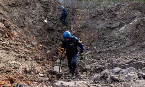 Ukrainian bomb disposal experts search for remnants of a Russian S-300 missile that hit near one of the schools in Kharkiv, Ukraine.