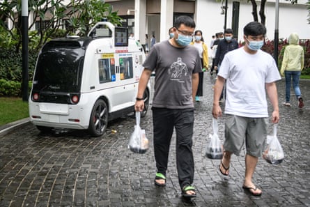 Men walking away from an automated food truck with bags