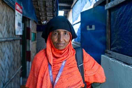 A woman in an orange chador and black headscarf.