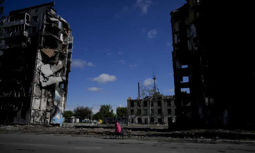 A woman rides a bicycle near buildings destroyed by attacks in Borodyanka, on the outskirts of Kyiv, Ukraine.