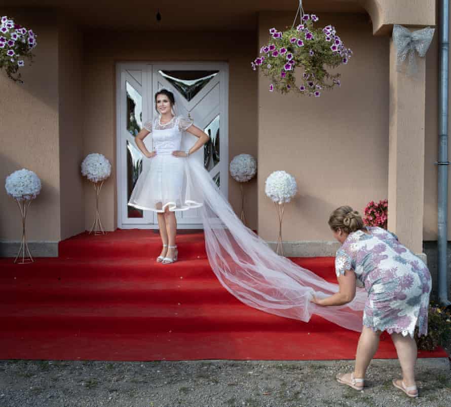 Jesica Monica Bura poses for a portrait in front of her parents' house in Camarzana