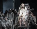 In Parsifal, a dishevelled, barefoot man cries out atop a mechanical stage structure as hooded figures watch