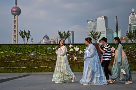 Young women wear traditional costumes while walking at the Bund along the Huangpu River in Shanghai 2 June