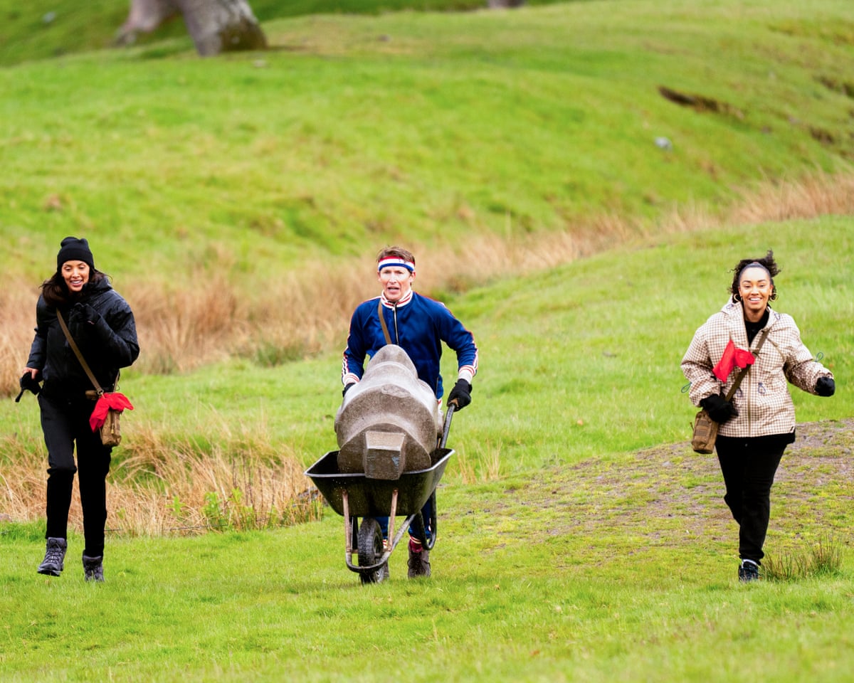 James Blunt pushes a boulder in a wheelbarrow, flanked by Maya Jama and Leigh-Anne Pinnock