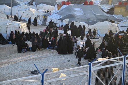 Women and children next to the tent encampment inside the camp