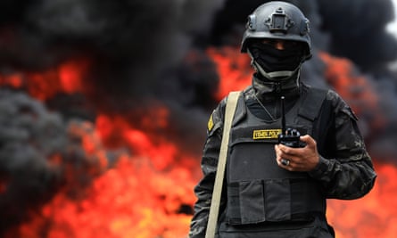 A Houthi soldier keeps watch as flames rise from a burning pile of seized narcotic drugs on 20 July.