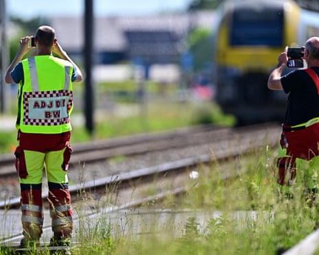 Emergency services take images with their smartphones at the site of an accident after a train crashed into a school bus, at the railway crossing Vierhuizen in Buggenhout, Belgium.