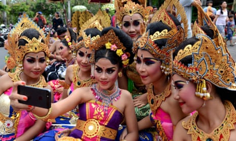 Balinese young girl take a selfie during a New Year celebration in Denpasar, on Indonesia’s resort island of Bali.