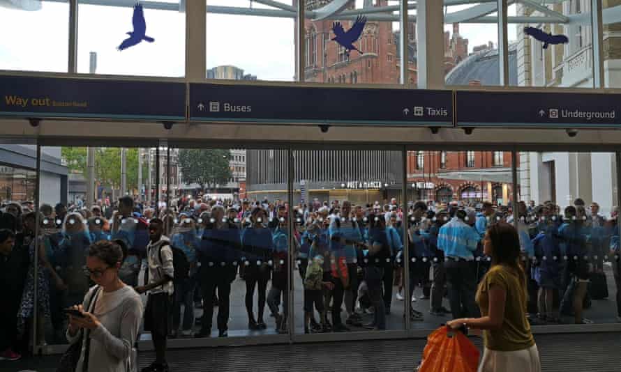 People wait outside King's Cross station in London on the day of the blackout