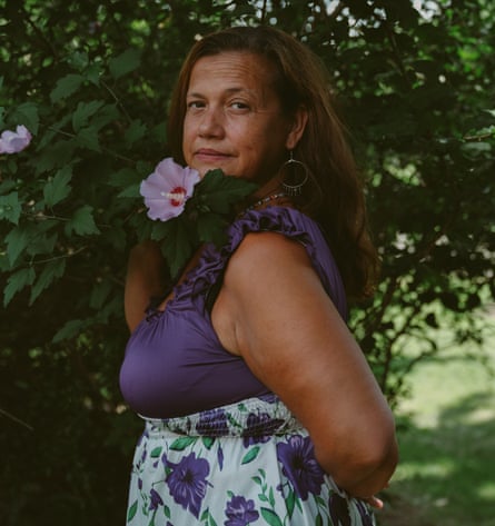 Yorleny Weigel, wearing a purple top and floral skirt, and holding a flower