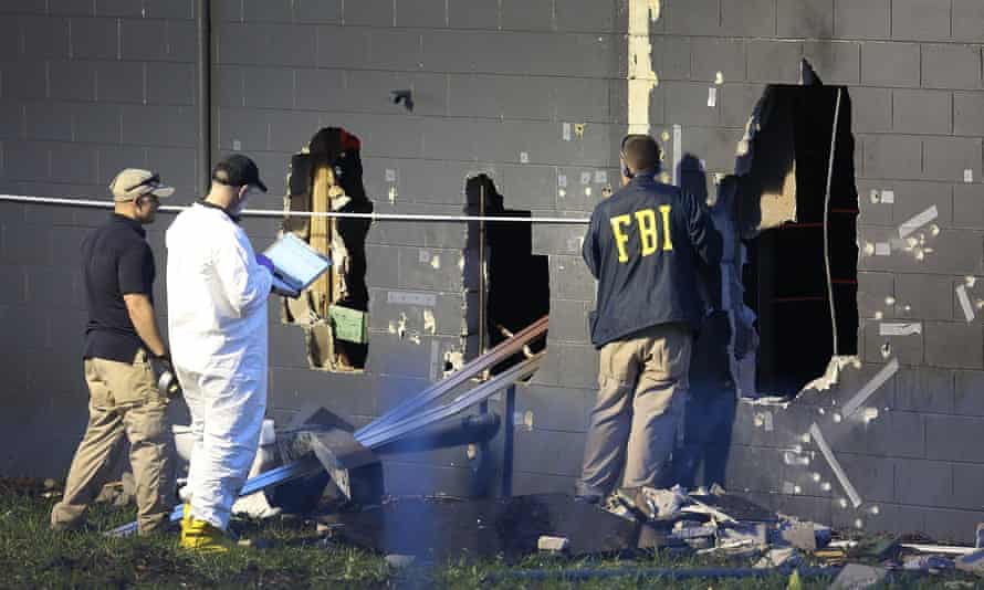 FBI agents investigate near the damaged rear wall of Pulse on Sunday in Orlando, Florida.