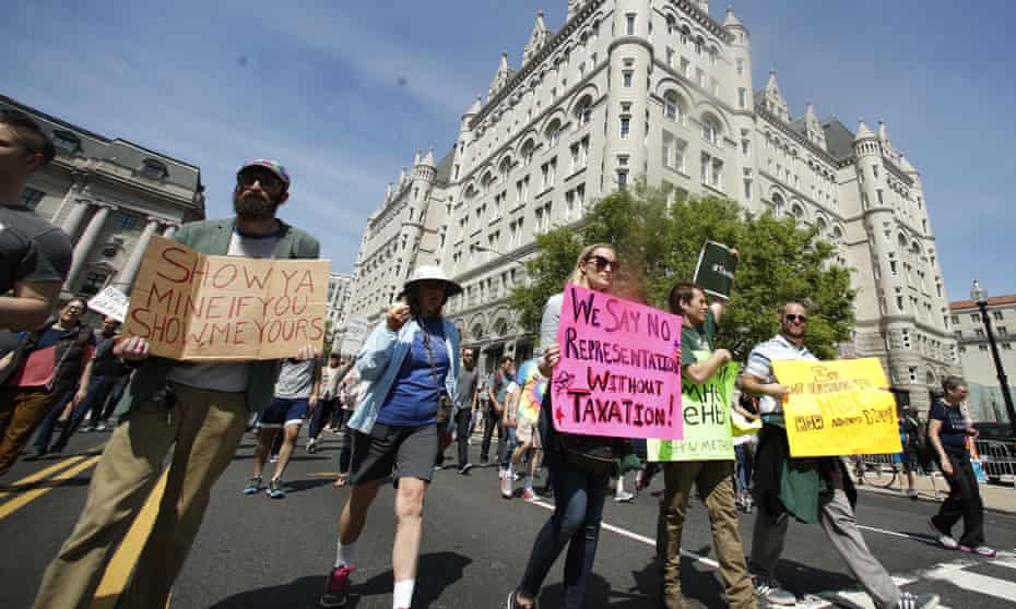 Protesters march past the Trump International Hotel in Washington, 15 April, 2017.