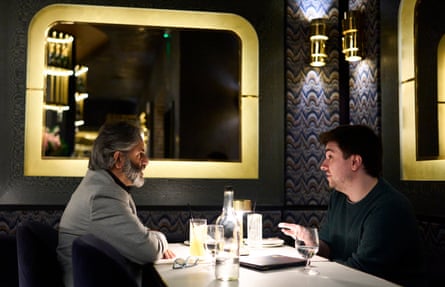 Two men facing each other across a restaurant table